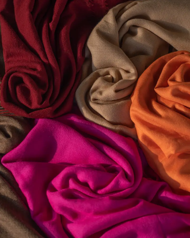 Stack of lamb wool shawls in warm colours