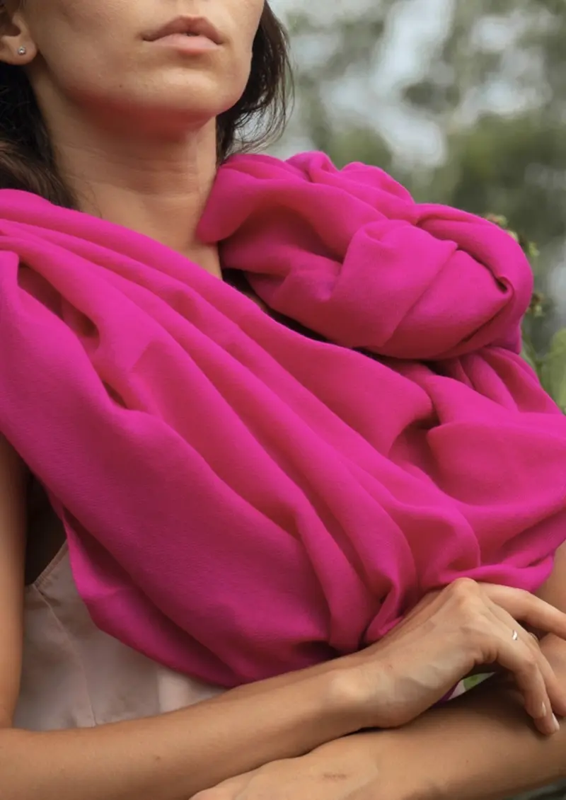 Close-up of a vivid pink Lamb wool shawl, showing the lips and hands